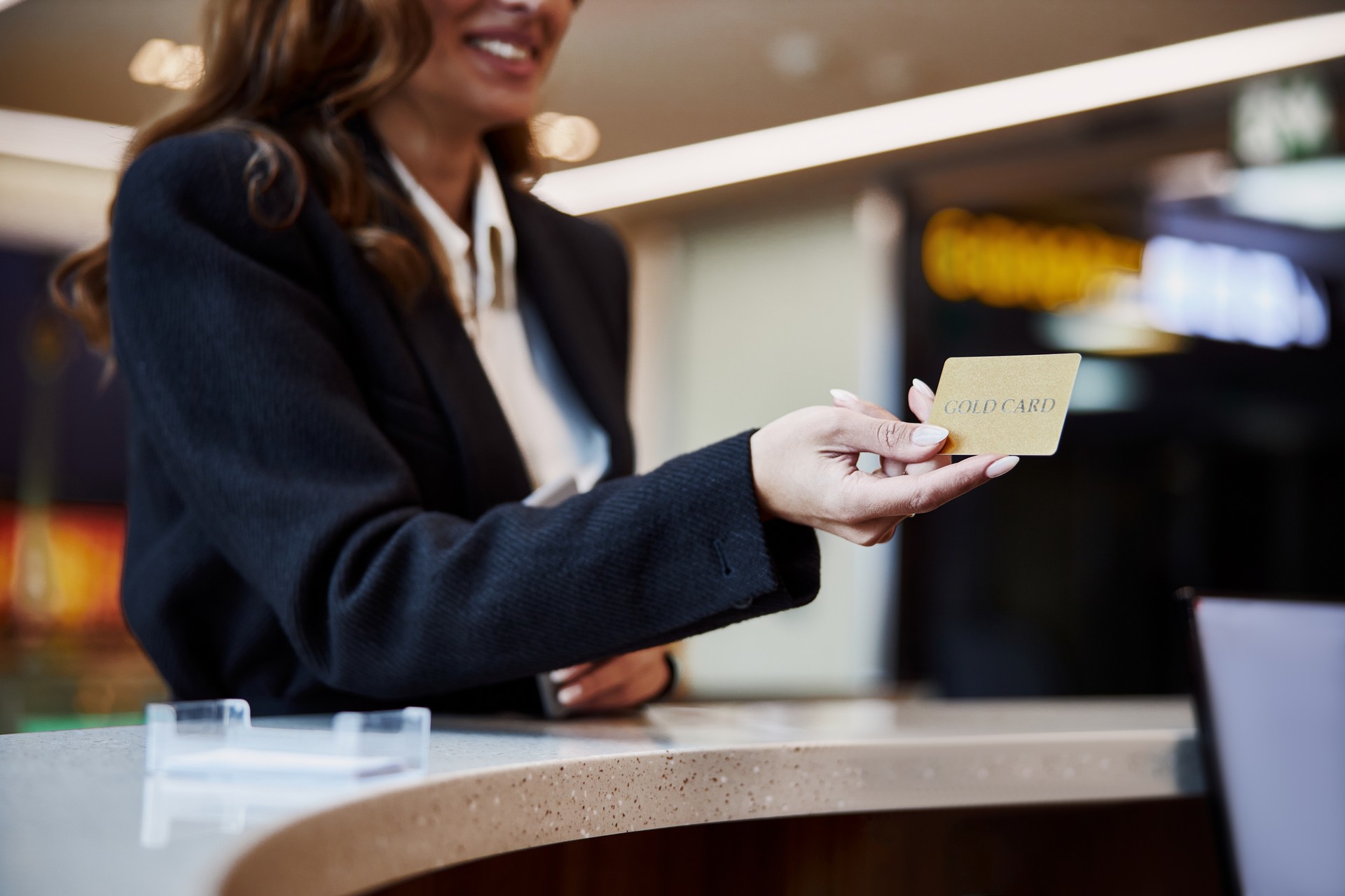 Young woman using gold card and smiling